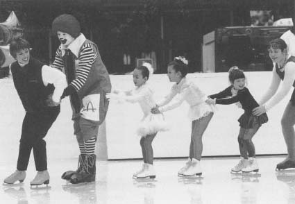 Olympic skater Dorothy Hamill lends Ronald McDonald a hand in entertaining some young skaters at a fund-raising event for the Ronald McDonald House Charities. Reproduced by permission of AP/Wide World Photos.